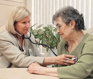 Nurse listens to a patient's heart.